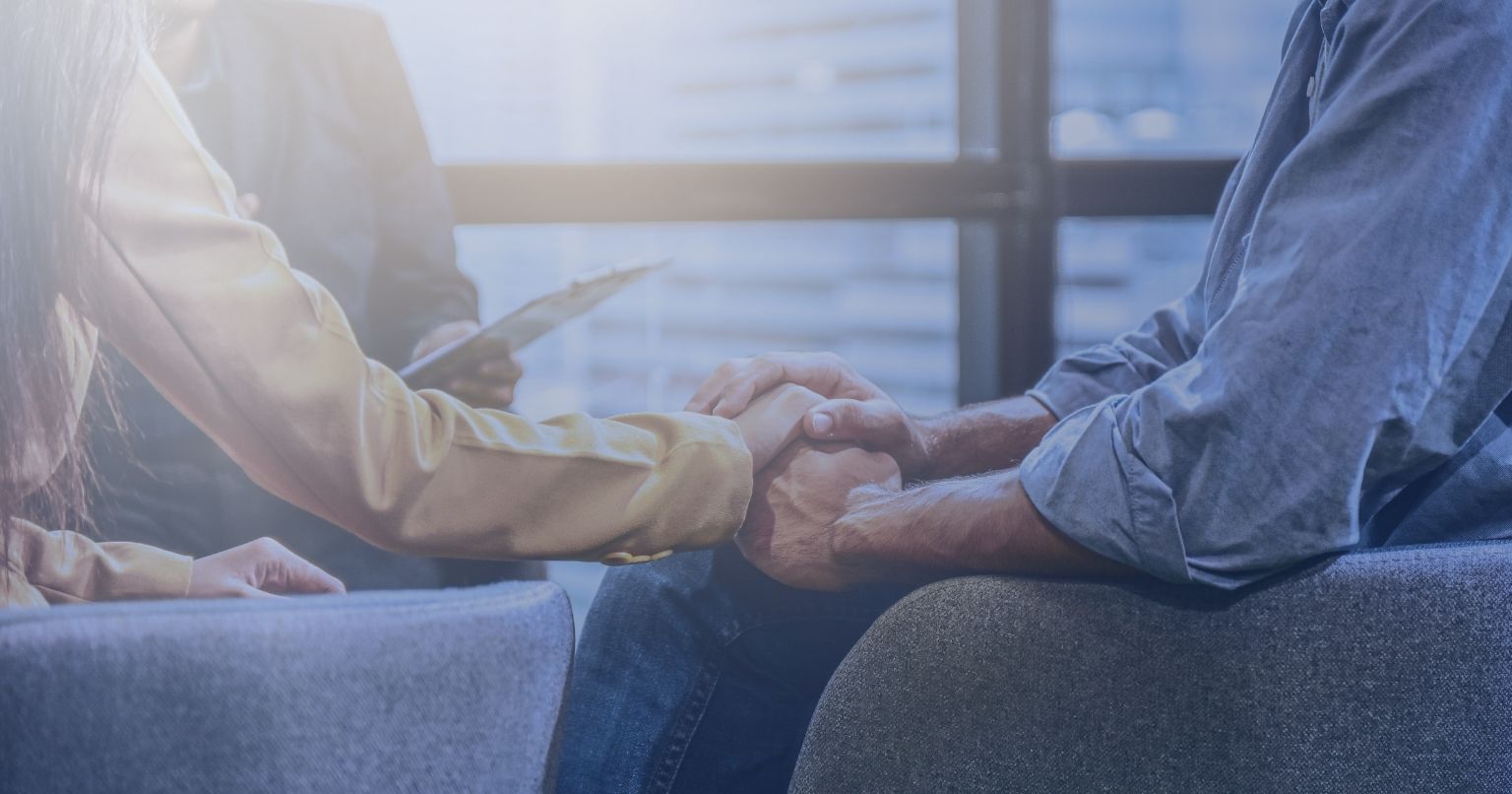 Couple holding hands in therapy session, symbolizing trust and support